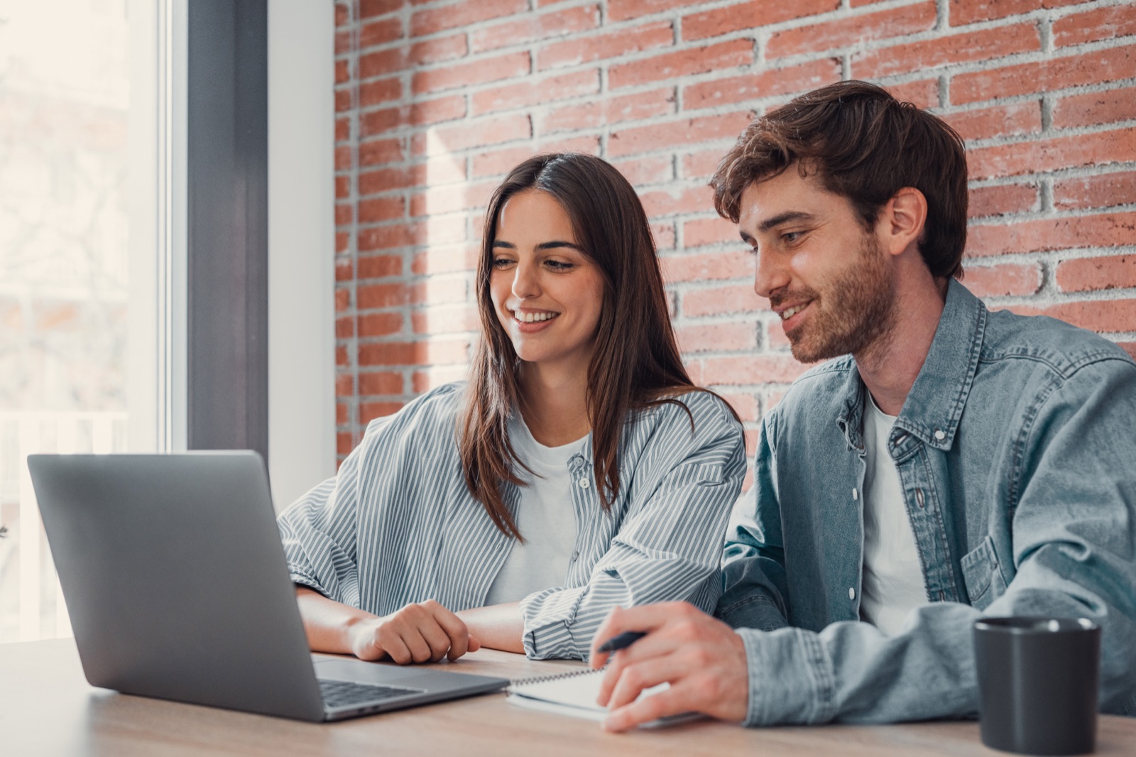 Pareja millennial trabajando con laptop en casa