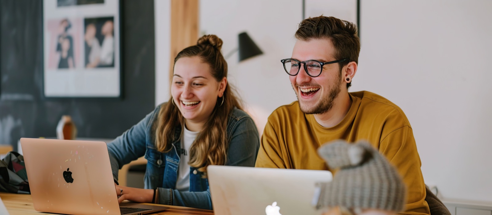 Jóvenes profesionales riendo frente a un laptop